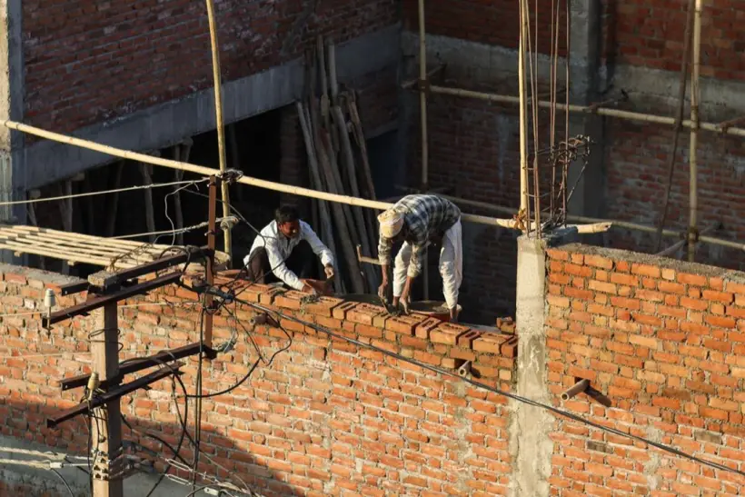 Bricklayers building the walls of a house
